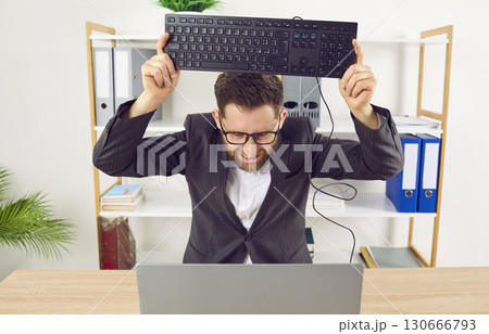 Office worker gets angry because of computer problem and wants to smash keyboard on it Office worker gets angry because of computer problem and wants to smash keyboard on it 130666793