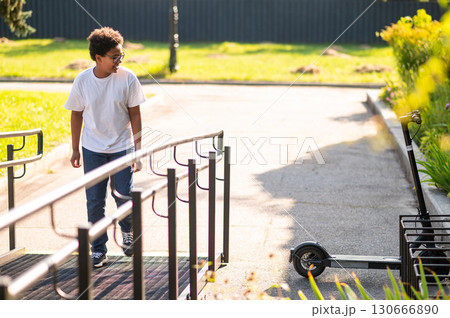 Boy in a white thsirt walking on the bridge in the park Boy in a white thsirt walking on the bridge in the park 130666890