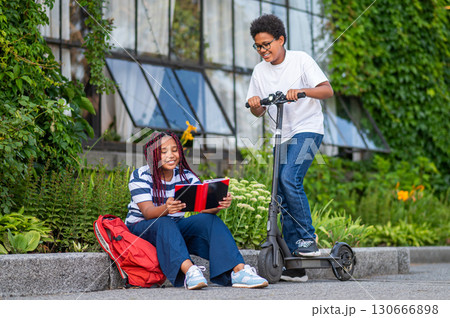 Two teens discussing something after school and looking involved Two teens discussing something after school and looking involved 130666898
