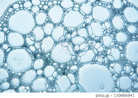 The texture of soap bubbles and foam in close-up on a blue background. The texture of soap bubbles and foam in close-up on a blue background. 130666941