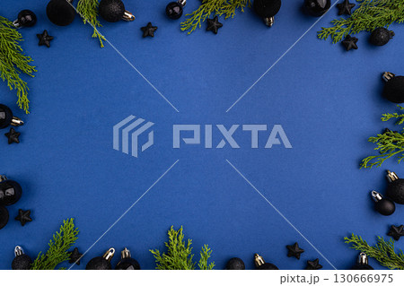 Black Christmas Ornaments and Greenery on Blue Background 130666975