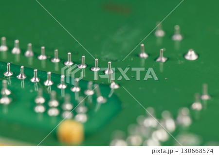 circuit board with contacts, a green printed circuit board with an electronic circuit with soldered elements circuit board with contacts, a green printed circuit board with an electronic circuit with soldered elements 130668574