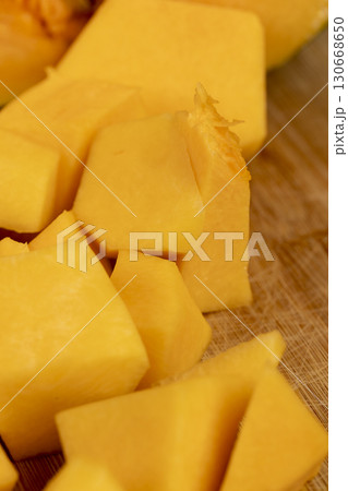cut bright orange ripe pumpkin for cooking, cut into pieces sweet pumpkin in the kitchen, closeup cut bright orange ripe pumpkin for cooking, cut into pieces sweet pumpkin in the kitchen, closeup 130668650