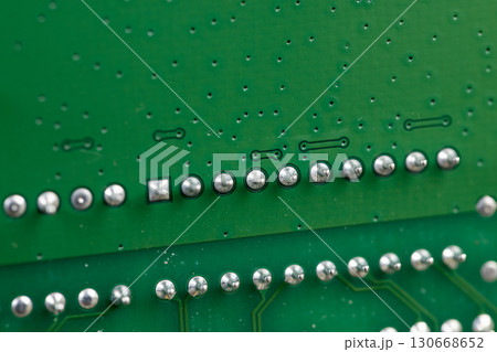 a printed circuit board with an electronic circuit with soldered elements, close up 130668652