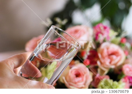 水の入ったコップを持つ手 華やかな花束 花に水のイメージ 水の入ったコップを持つ手 華やかな花束 花に水のイメージ 130670079