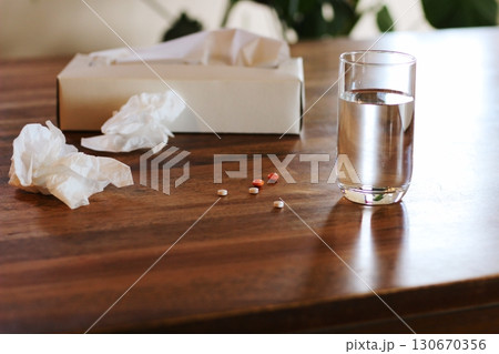 丸めたテッシュペーパーと水の入ったコップ 錠剤 白いティッシュ箱 室内 丸めたテッシュペーパーと水の入ったコップ 錠剤 白いティッシュ箱 室内 130670356