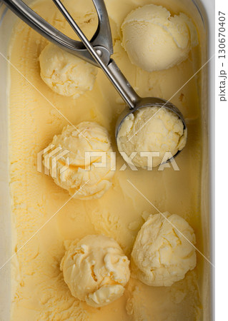 Vanilla ice cream scoops in tray with scoop utensil, close-up food background 130670407
