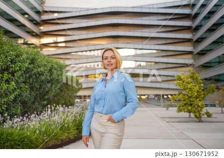 Confident young blond businesswoman standing Confident young blond businesswoman standing 130671952