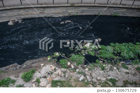Bagmati river at Pashupatinath temple in Kathmandu, Nepal. This river contains large amounts of untreated sewage, and large levels of pollution of the river exist due to the region's population. Bagmati river at Pashupatinath temple in Kathmandu, Nepal. This river contains large amounts of untreated sewage, and large levels of pollution of the river exist due to the region's population. 130675729