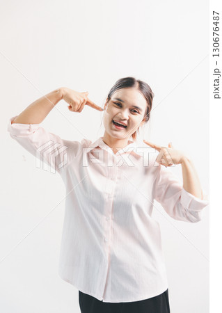 Asian woman rejoicing, looking happy, champion, fist pump gesture, standing over white background. young woman had happy, positive expression on her face, highlighted by bright smile. Asian woman rejoicing, looking happy, champion, fist pump gesture, standing over white background. young woman had happy, positive expression on her face, highlighted by bright smile. 130676487