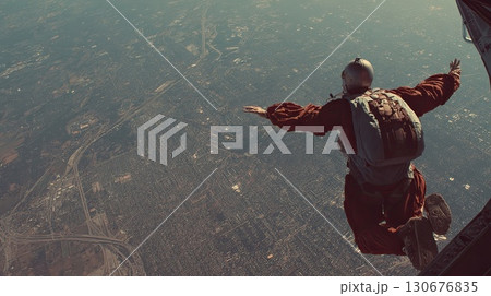 Skydiver is flying over landscape with clouds and mountains 130676835