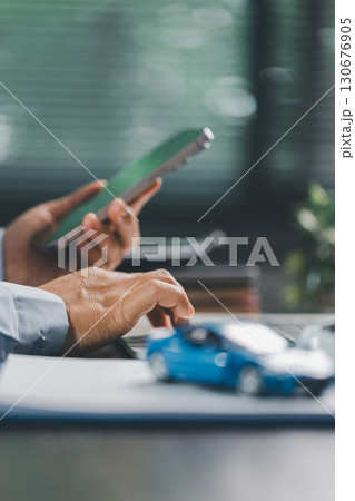 Car loan approval concept. Client finalizes purchase of vehicle by signing contract includes auto loan, insurance, credit terms, making car smart financial investment business-backed finance option. Car loan approval concept. Client finalizes purchase of vehicle by signing contract includes auto loan, insurance, credit terms, making car smart financial investment business-backed finance option. 130676905