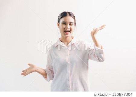 Asian woman rejoicing, looking happy, champion, fist pump gesture, standing over white background. young woman had happy, positive expression on her face, highlighted by bright smile. 130677304