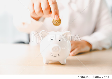 Businesswoman focused on saving money, smart financial planning, using banking, investment strategies to grow business, build wealth, achieve success while contributing to overall economy growth. 130677363