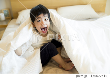 ベッドで寝転ぶ幼児 130677410