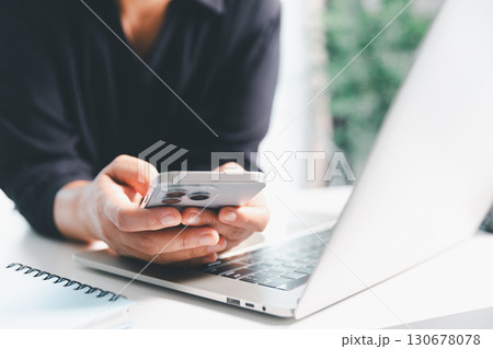 Close-up scene, a female seated at a table holds a smartphone, spending time on modern e-date services and social media through a mobile app, illustrating the wireless concept of digital usage. Close-up scene, a female seated at a table holds a smartphone, spending time on modern e-date services and social media through a mobile app, illustrating the wireless concept of digital usage. 130678078