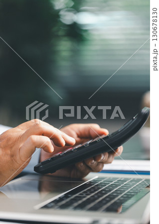 Businesswoman at table, calculator, monthly tax calculations, budgeting, managing expenses-illustrating business, finance, accounting, banking concept essential for effective budget management. 130678130