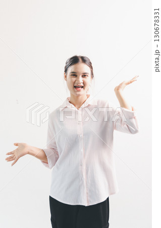 Asian woman rejoicing, looking happy, champion, fist pump gesture, standing over white background. young woman had happy, positive expression on her face, highlighted by bright smile. 130678331