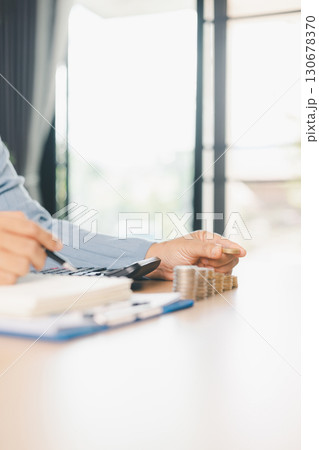 Hand places coin into saving jar, representing how smart finance, investment, banking practices turn money, cash, currency into financial wealth drives business growth and strengthens the economy. 130678370