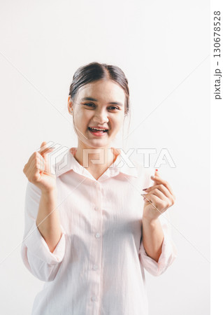 Asian woman rejoicing, looking happy, champion, fist pump gesture, standing over white background. young woman had happy, positive expression on her face, highlighted by bright smile. 130678528