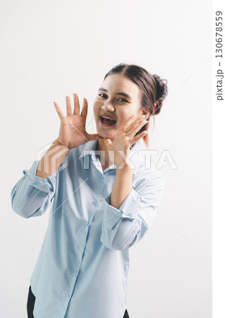 Asian woman rejoicing, looking happy, champion, fist pump gesture, standing over white background. young woman had happy, positive expression on her face, highlighted by bright smile. 130678559