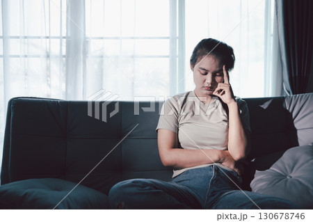 Sorrowful woman sat alone, overwhelmed by emotion, her sad and unhappy expression revealing deep despair, stress and distress left feeling depressed. sorrowful sad, despair alone, depressed stress 130678746