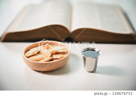 Christianity, holy communion ceremony is sacred act of worship and faith, where bread and wine in chalice symbolize body and blood of Christ in the religious eucharist tradition. 130678752