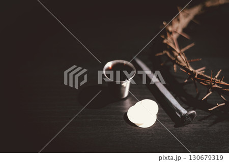 Holy Bible with communion bread, wine, crown of thorns and crucifixion nail symbolizing the sacrifice of Jesus Christ, His suffering, crucifixion and salvation through the cross. 130679319