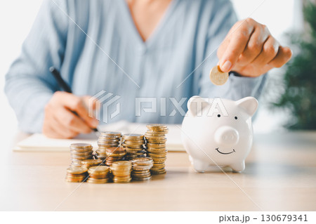 Businesswoman focused on saving money, smart financial planning, using banking, investment strategies to grow business, build wealth, achieve success while contributing to overall economy growth. 130679341