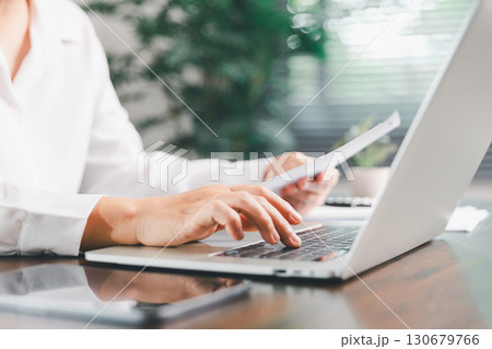 Businesswoman manages finances by using banking and accounting system to calculate costs, taxes, investments, illustrating a business, finance, and real estate concept focused on financial strategy. 130679766