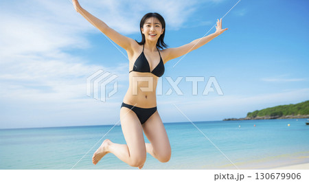 ビキニの女性　両手を広げて空を背景にジャンプする元気な姿 130679906