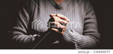 Person clasping hands in prayer, symbolizing faith, hope, spirituality, devotion, inner strength, meditation, belief, healing and the power of trust during difficult times in life. Person clasping hands in prayer, symbolizing faith, hope, spirituality, devotion, inner strength, meditation, belief, healing and the power of trust during difficult times in life. 130680075