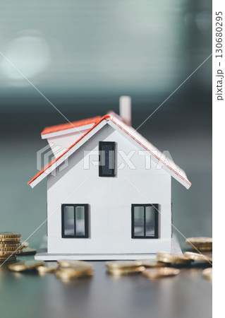 House model placed beside money coins illustrates concept of saving and financial planning for buying home, highlighting investment, mortgage options, home loans, refinancing, smart finance strategies 130680295