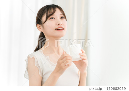 朝、家で白湯・コーヒー・ホットドリンク・カフェオレ・カフェラテを飲む笑顔のアジア人女性 朝、家で白湯・コーヒー・ホットドリンク・カフェオレ・カフェラテを飲む笑顔のアジア人女性 130682039