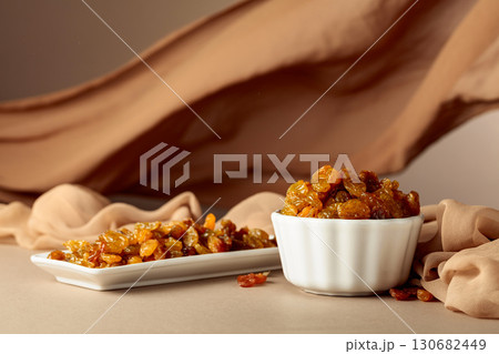 Yellow sultana raisins in a white bowl. Yellow sultana raisins in a white bowl. 130682449