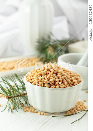 Peeled pine nuts on a white wooden table. 130682486
