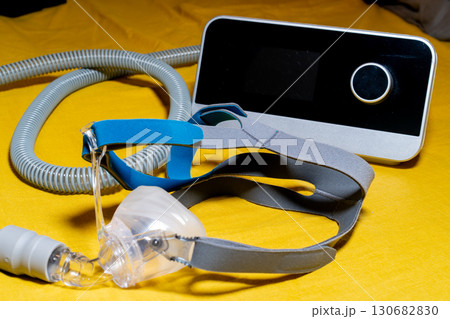 Tube and mask of the Obstructive Sleep Apnea CPAP Machine on a yellow surface. Tube and mask of the Obstructive Sleep Apnea CPAP Machine on a yellow surface. 130682830
