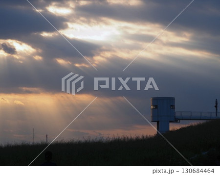 夕方の雲の切れ間から地上に降りそそぐ薄明光線 夕方の雲の切れ間から地上に降りそそぐ薄明光線 130684464