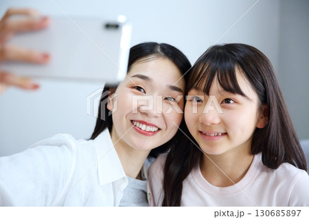 スマホで自撮りをするママと娘の親子イメージ 130685897