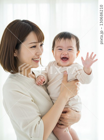 笑顔で赤ちゃんを抱っこする母親と幸せな親子の時間 笑顔で赤ちゃんを抱っこする母親と幸せな親子の時間 130686210