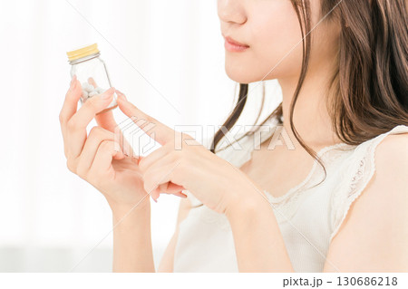 薬・サプリメントの成分をチェックするアジア人女性 薬・サプリメントの成分をチェックするアジア人女性 130686218