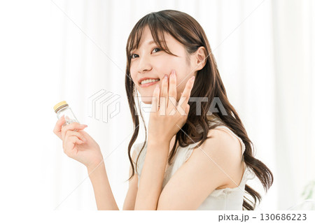 薬・サプリメントの瓶を持つ笑顔のアジア人女性 130686223