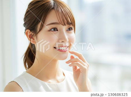 笑顔で見上げる若い女性のポートレート 130686325