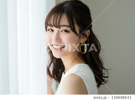 笑顔の若い女性ポートレート　窓辺で微笑む姿 130686631