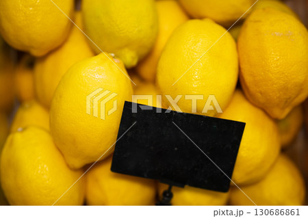 Fresh lemons with price tag on black background. Fresh lemons with price tag on black background. 130686861