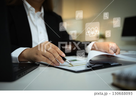Modern HR management concept with businesswoman reviewing employee data and digital interface icons 130688093