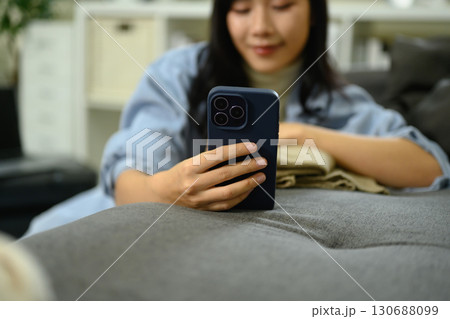 Young woman using smartphone, checking travel plans and preparing for her trip Young woman using smartphone, checking travel plans and preparing for her trip 130688099
