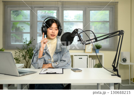 Young woman recording podcast with professional microphone in a home studio 130688215