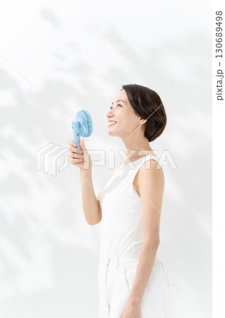 ハンディファンで涼む女性 130689498