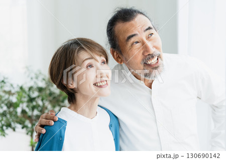 窓際で外を見るシニア夫婦 130690142